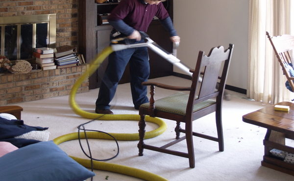 Person cleaning a carpet with professional vacuum