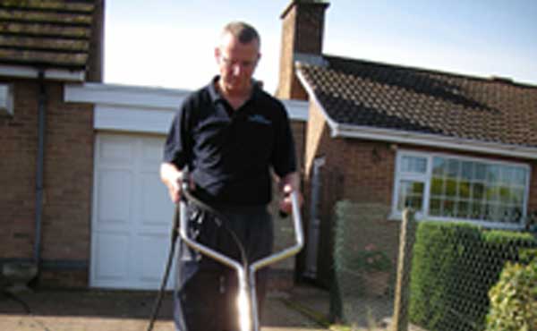 Person cleaning driveway with specialised machinery
